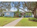 Single-story home with walkway and lush landscaping under large tree at 818 37Th Ne Ave, St Petersburg, FL 33704