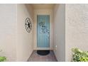 Light teal front door with decorative metalwork and brick flooring at 20644 Swallow Tail Ct, Venice, FL 34293