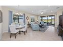 Open-concept living and dining area with light tile flooring and comfy seating at 20644 Swallow Tail Ct, Venice, FL 34293