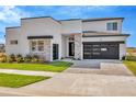 Modern two-story home with gray and white exterior, stone accents, and a black garage door at 32354 Wetland Bird Vw, San Antonio, FL 33576