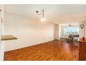 A large living room with wood floors, views of a piano and access to other rooms at 801 83Rd N Ave # 511, St Petersburg, FL 33702