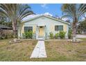 Quaint light green house with yellow shutters, walkway, and palm trees at 1701 32Nd N Ave, St Petersburg, FL 33713