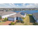 Aerial view of a house with a lake in the background at 19494 Sea Glass Cir, Land O Lakes, FL 34638