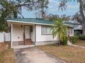 House exterior with a green metal roof and a spacious driveway at 728 Bay St, Dunedin, FL 34698