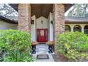 Elegant entryway with brick columns, a red door, and ornate planters at 807 Belle Timbre Ave, Brandon, FL 33511