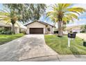 Single-story house featuring a paver driveway and palm trees at 6208 Spoonbill Dr, New Port Richey, FL 34652