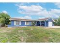 Ranch-style home with a large yard and blue exterior at 911 Silver Palm Way, Apollo Beach, FL 33572