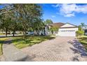 Landscaped front yard, brick driveway, and a charming house exterior at 16310 Ashington Park Dr, Tampa, FL 33647