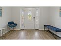 Entryway with a white door, blue chair, and bench at 394 Ulelah Ave, Palm Harbor, FL 34683