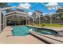 Screened-in pool and spa area with surrounding backyard at 394 Ulelah Ave, Palm Harbor, FL 34683