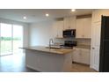 Modern kitchen featuring white cabinets, granite countertops, and stainless steel appliances at 31693 Wild Grape Lane, Brooksville, FL 34602