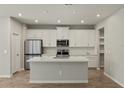 Modern kitchen with white cabinets, quartz countertops, and stainless steel appliances at 31496 Woodland Race Loop, Wesley Chapel, FL 33545