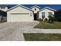 A charming one-story home with a two-car garage and a neatly landscaped front yard at 6625 Pebblebrooke Way, Zephyrhills, FL 33541