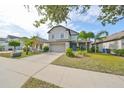 Two-story house with gray siding, light blue shutters, and a stone facade at 14319 Italia Dr, Wimauma, FL 33598