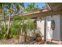 Front entrance with white door, stained glass, and tropical plants at 587 Hillcrest Dr, Largo, FL 33771