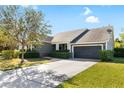 Two-story home with gray siding, a two-car garage, and lush landscaping at 6650 Current Dr, Apollo Beach, FL 33572