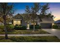 Attractive home exterior at dusk, featuring landscaping and a two-car garage at 6650 Current Dr, Apollo Beach, FL 33572