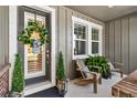 Inviting front porch with wooden rocking chairs, wreath, and potted plants at 6650 Current Dr, Apollo Beach, FL 33572