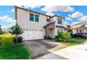 Two-story house with a three-car garage, landscaping and paver driveway at 21680 Violet Periwinkle Dr, Land O Lakes, FL 34637