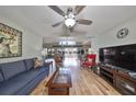 Bright living room with hardwood floors, ceiling fan, and comfortable furnishings at 407 Blackhawk Cir, Sun City Center, FL 33573