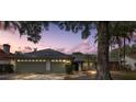 Two-car garage, mature landscaping, and a spacious front yard at dusk at 15106 Meadowlake St, Odessa, FL 33556