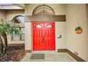 Bright red double front doors with a welcome sign at 161 Woodcreek N Dr, Safety Harbor, FL 34695