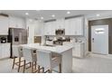 Modern kitchen with white cabinets and island at 17554 Holly Well Ave, Wimauma, FL 33598