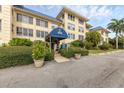 Condo building entrance with covered walkway and landscaping at 3806 Gulf Of Mexico Dr # C211, Longboat Key, FL 34228