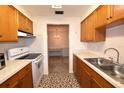 Kitchen with wood cabinets, white appliances, and view into dining area at 4315 Aegean Dr # 110C, Tampa, FL 33611
