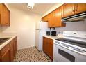 View of kitchen with white appliances and wood cabinets at 4315 Aegean Dr # 110C, Tampa, FL 33611