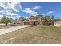 Two story home featuring an attached garage and a well-manicured lawn at 2359 Gimlet Ave, Spring Hill, FL 34608