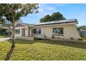 House exterior with solar panels and well-maintained lawn at 2708 Fulton Sw St, Largo, FL 33774