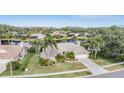 Aerial view showcasing the home, lush landscaping, and a serene lake at 3360 Hickorywood Way, Tarpon Springs, FL 34688
