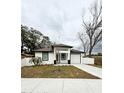 Modern white house with black trim, two car garage, and a small front yard at 408 E Hanlon St, Tampa, FL 33604