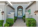 Elegant entryway with double doors, arched window, and brick pathway at 4919 Pamplona Ct., Wimauma, FL 33598