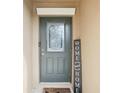 Gray front door with glass panel and welcome sign at 2964 Moulden Hollow Dr, Zephyrhills, FL 33540