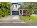 Two-story home with gray siding, a dark gray garage door, and a landscaped front yard at 1839 46Th N Ave, St Petersburg, FL 33714