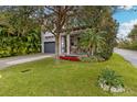 Two-story home with gray siding, a dark gray garage door, and a landscaped front yard at 1839 46Th N Ave, St Petersburg, FL 33714