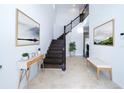 Bright and spacious entryway with a wooden staircase and decorative artwork at 2941 Adams Cross Dr, Zephyrhills, FL 33540