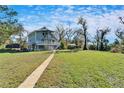 Elevated home, large grassy yard, and walkway leading to house at 4501 Keene Rd, Plant City, FL 33565