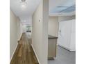 Hallway view of living room and kitchen with wood-look floors at 3500 Lake Bayshore Dr # K-101, Bradenton, FL 34205