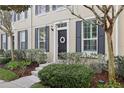 Townhome entrance with black door, shutters, and well-maintained landscaping at 9910 New Parke Rd, Tampa, FL 33626