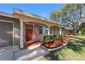 Front entrance with red door, brick facade, and nicely landscaped area at 1340 Williams Dr, Clearwater, FL 33764