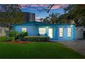 Quaint light blue house with a lush green lawn at dusk at 6210 S Harold Ave, Tampa, FL 33616