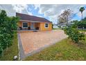 Cute yellow house with brick paver driveway at 7211 Waycross Ave, Tampa, FL 33619