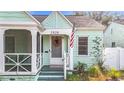 Front view of a charming light teal house with a white porch at 2828 Burlington N Ave, St Petersburg, FL 33713