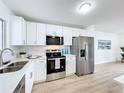 Renovated kitchen with white cabinets, stainless steel appliances, and quartz counters at 3932 Ashwood Ln # 42, Sarasota, FL 34232