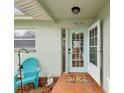 Quaint front entrance with a light teal door and welcome mat at 1611 Brook Dr, Dunedin, FL 34698