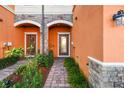 Attractive entryway with stone accents, arched doorways, and well-maintained landscaping at 20252 Lagente Cir, Venice, FL 34293