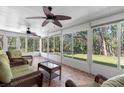 Relaxing screened porch with wicker furniture and view of backyard at 3203 Audubon Ct, Tarpon Springs, FL 34688